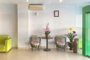 a waiting room with a table and chairs and flowers at Urbanview Hotel Mulia Indah Palopo in Palopo