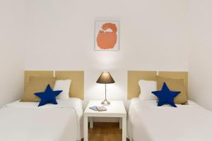 duas camas num quarto com estrelas azuis em Sardenya Apartment by Olala Homes em Barcelona