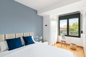 a bedroom with a large white bed and a window at Sardenya Apartment by Olala Homes in Barcelona