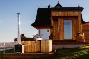 a wooden house with a hot tub on a deck at Osada Dursztyn- Przystanek Podhale in Białka Tatrzanska