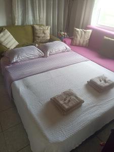 a large bed with two towels on top of it at zacharenia's home in Mirodháton