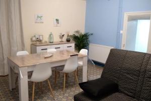 a dining room with a table and white chairs at Gîte léperon 4 in Clisson