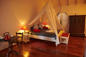 Schlafzimmer mit einem Bett mit Moskitonetz in der Unterkunft LE JARDIN DU FORT - GALLE in Galle