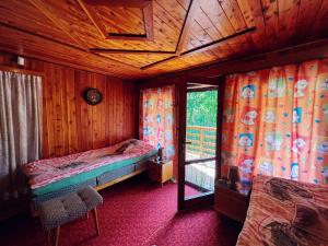 a small bedroom with a bed and a window at Hunting lodge under the rock and the river Kretinka in Bystré