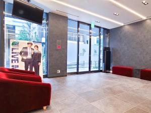 a man and woman standing in a room with a screen at HOTEL LiVEMAX Akasaka GRANDE in Tokyo