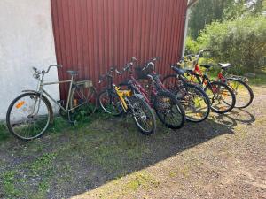un grupo de bicicletas estacionadas junto a una pared roja en Luxury cosy cottage by the sea en Karlstad