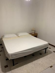 uma cama num quarto com uma parede branca em Casa vacanze Gilli em Cagliari