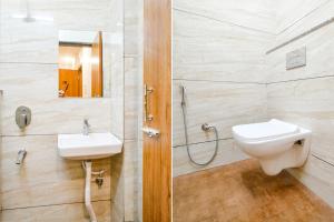 a bathroom with a toilet and a sink and a shower at FabHotel Woodlark Inn in Indore