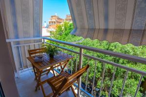 a balcony with a wooden table and two chairs at Central Apartment in Xylokastron