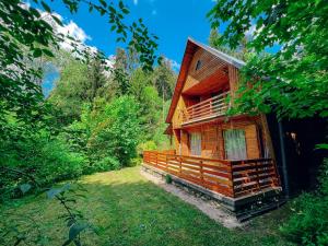 a wooden cabin in the middle of a forest at Hunting lodge under the rock and the river Kretinka in Bystré