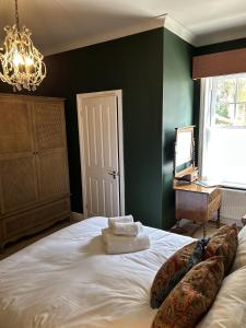a bedroom with a large white bed with a chandelier at The Lodge at Salhouse in Norwich