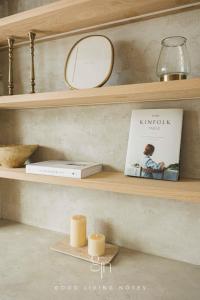 a shelf with a book and a mirror and candles at 瀉湖-私人公寓 The Lagoon-Mediterranean vibe vacation house in Kaohsiung