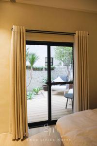 高雄的住宿－瀉湖-私人公寓 The Lagoon-Mediterranean vibe vacation house，卧室设有滑动玻璃门,可通往庭院。
