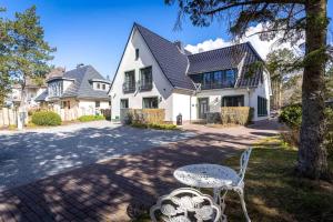 圣彼得奥尔丁Hotel TWEED的白色的房子,配有桌子和椅子