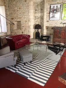 a living room with a red couch and a table at Belle maison historique in Arles