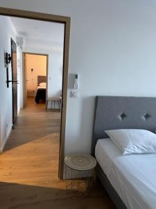 a bedroom with a bed and a mirror and a hallway at Appartement F3 Corte, centre ville in Corte