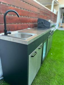 a kitchen with a sink in the grass at דירת גן על הים בנהריה in Nahariyya