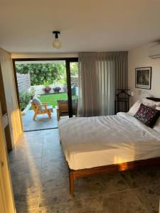 1 dormitorio con cama y vistas a un patio en דירת גן על הים בנהריה, en Nahariyya
