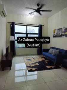 a living room with a blue couch and a ceiling fan at Az-Zahraa Putrajaya - Residences Presint 8 in Putrajaya
