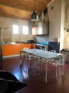 une cuisine avec une table blanche et quelques armoires orange dans l'établissement Belle maison historique, à Arles