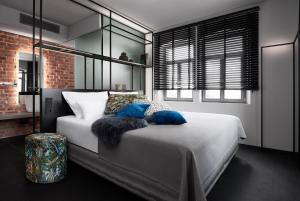 una camera da letto con un grande letto bianco con cuscini blu di Mittermeiers Alter Ego a Rothenburg ob der Tauber