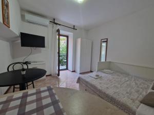 a room with a bed and a table and a television at Old town - Studio1 in Tribunj