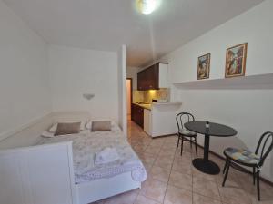 a bedroom with a bed and a table and a kitchen at Old town - Studio1 in Tribunj