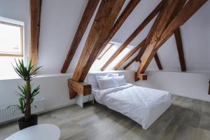 a bedroom with white walls and wooden beams at Palatul Lugoj in Lugoj