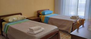 two beds in a room with towels on them at Residenza dal Barone in Paestum