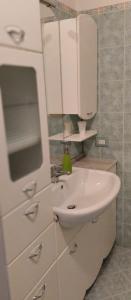 a white bathroom with a sink and a mirror at Residenza dal Barone in Paestum