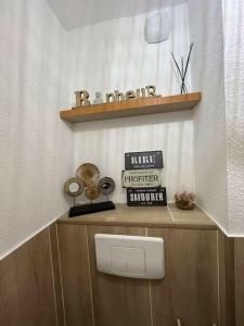 a bathroom with a wooden shelf and a toilet at Appartement jacuzzi mondonville in Mondonville