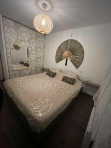 a bedroom with a bed with a lamp and a mirror at Appartement jacuzzi mondonville in Mondonville