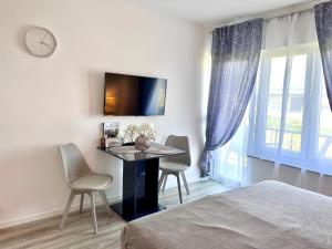 a bedroom with a desk with two chairs and a clock at Prime Host Lovely Apartment in Karlsruhe