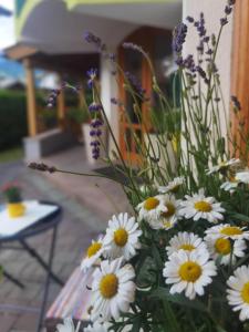 a vase filled with white and yellow flowers at Hotel Landhaus Zell am See in Zell am See