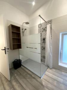 La salle de bains est pourvue d'une douche avec une porte en verre. dans l'établissement Maison pour séjour, à Mouzay