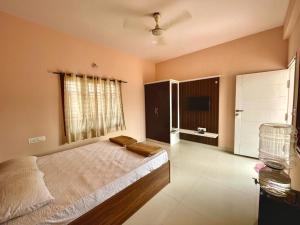a bedroom with a large bed and a window at BrickNest homes in Mysore