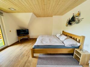 a bedroom with a bed and a flat screen tv at U Marků in Staré Splavy