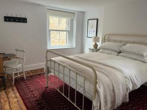 a bedroom with a bed and a desk and a window at Dene Cottage in Stanton in Peak