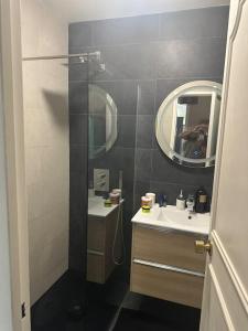 La petite salle de bains est pourvue d'un lavabo et d'un miroir. dans l'établissement Villa JO 2024, à Buc
