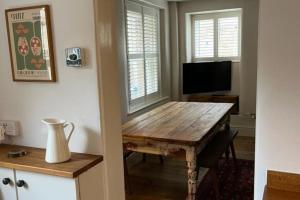 Dene Cottage في Stanton in Peak: غرفة معيشة مع طاولة خشبية وتلفزيون