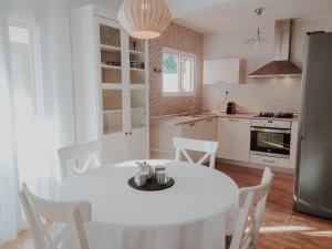 a white kitchen with a white table and chairs at Casa Familiar Tarragona playa in Tarragona