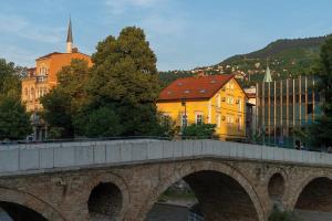 a bridge over a river in a city with buildings at Ornament Hotel in Sarajevo