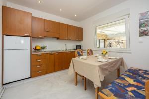 uma cozinha com uma mesa e um frigorífico branco em Amarie 2 em Dramalj