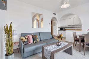 Una sala de estar con un sofá azul y una mesa. en Clementina Imperial Park, en Casas de Torrat