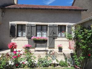 a house with two windows and flowers in front of it at Maison aux portes du centre historique de Dijon avec 3 chambres et garage in Dijon