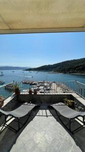 a balcony with two chairs and a view of the water at Seafront rooftop flat w/ terrace in Portovenere