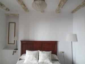 a bedroom with white walls and a bed with two pillows at Apartamentos Turísticos El Losal in Úbeda