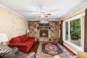 een woonkamer met een rode bank en een open haard bij Mountain View Bliss - Cozy 1BR Cabin in Sevierville