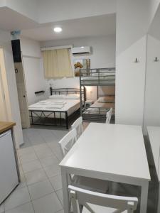 una cocina con mesas y sillas blancas en una habitación en Super economy studio en Agia Pelagia