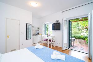 1 dormitorio con 2 camas y cocina con mesa en Apartments Villa Ivka, en Dubrovnik